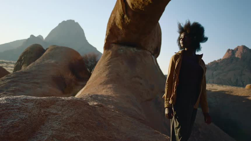 A woman is surrounded by rock formations in the mountains