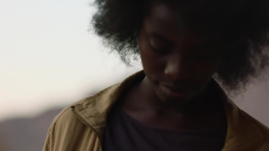 A young woman with afro walking around outdoors