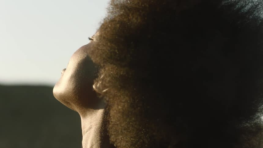 A woman leans back as the wind blows her hair