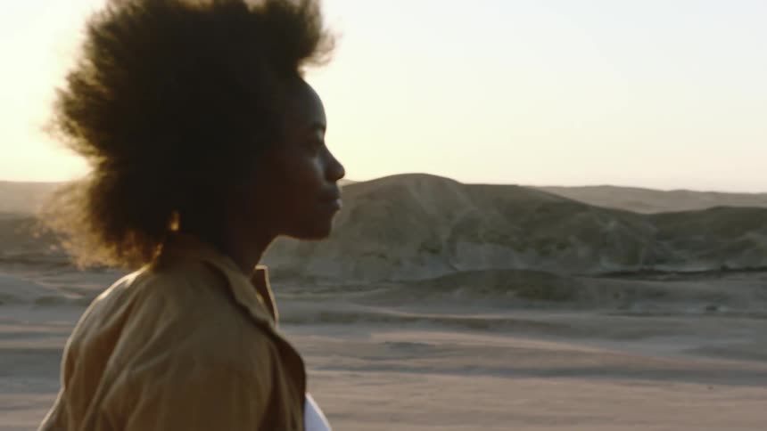 Black woman walking through the desert