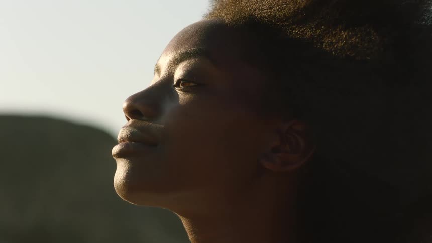 Black woman smiles while outdoors