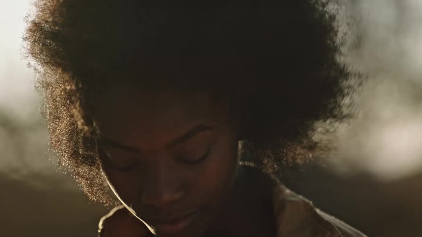 Black woman looks down on a windy day