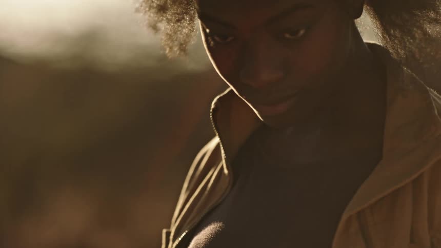 A woman is standing outside on a windy day