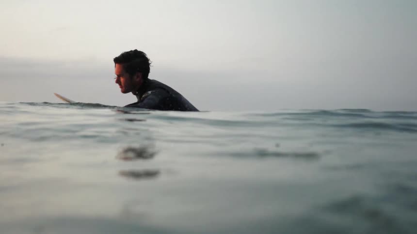 A man is on a surfboard on a cloudy day