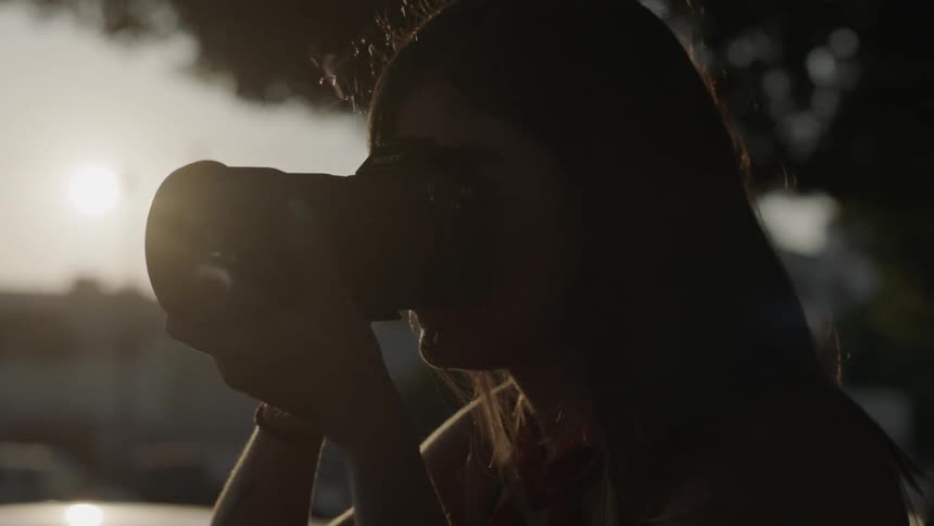 A woman adjusts a camera and takes a picture
