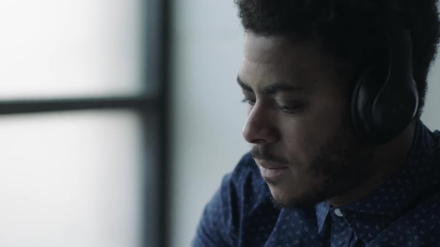 A black man listening to music with his headphone