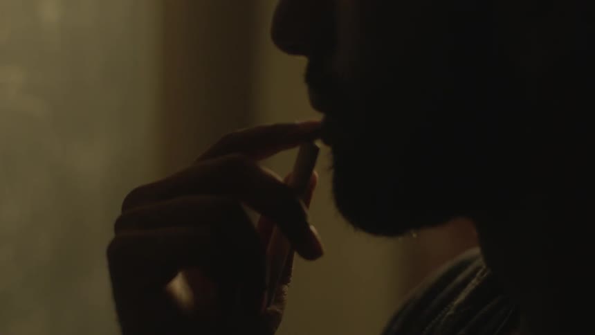 A man puts his fingers to his lip