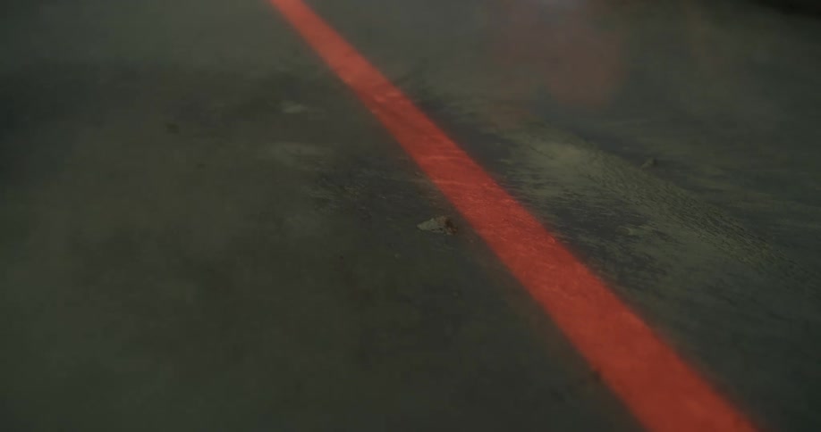 Red thick laser drawing a line on the concrete floor under white smoke