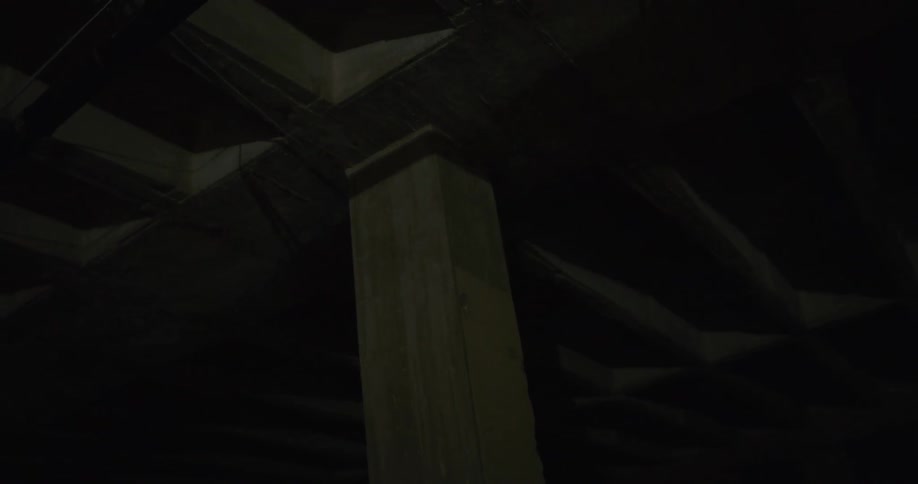 Red laser light scanning the roof walls and columns inside a dimly lit room