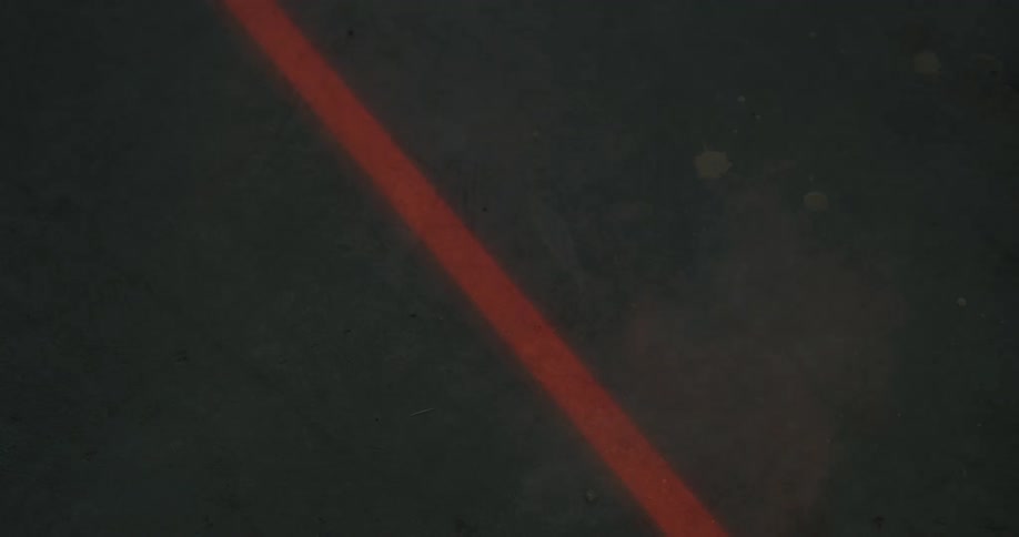 Smoke moves over an orange line painted on the concrete