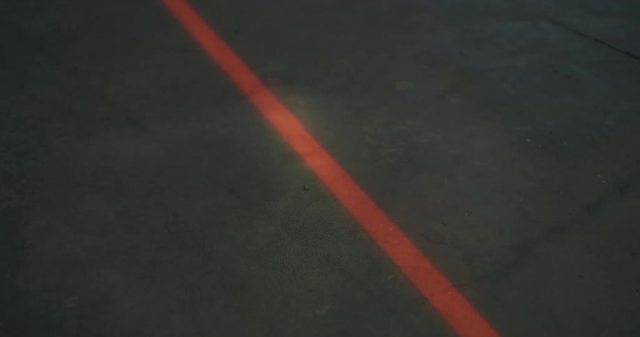 Sand or dirt is dropped on a red line on black asphalt