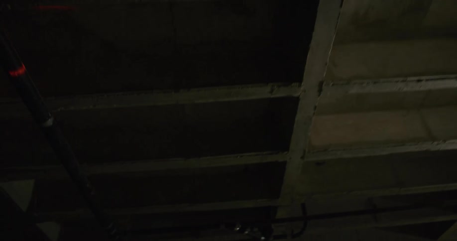 A red beam of light moving across a ceiling in a building