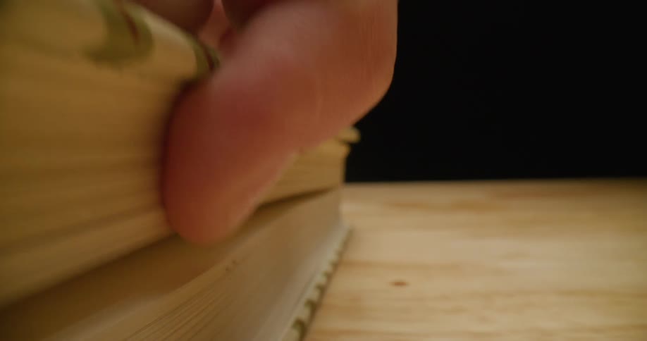 A person running their hand along a book and then opening it