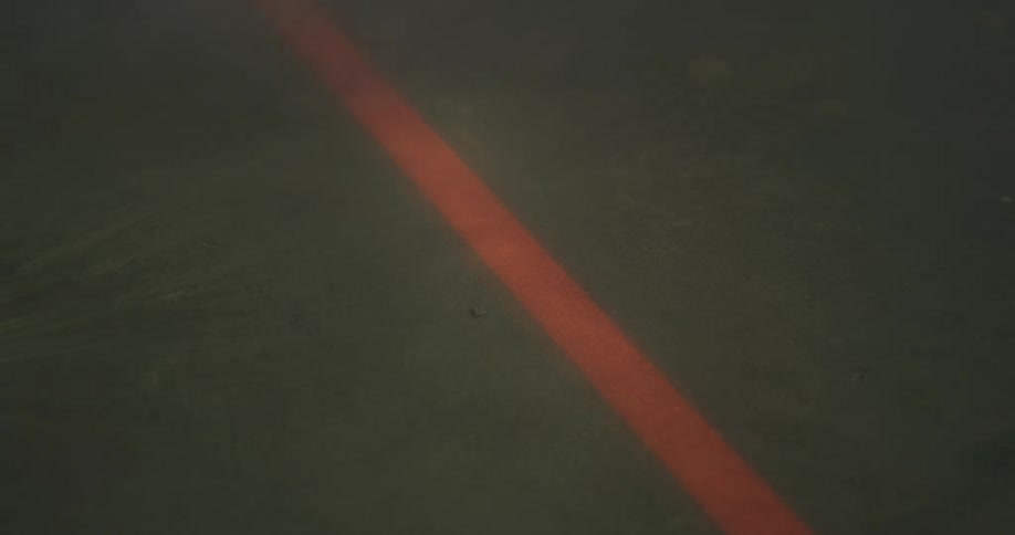 Smoke moves over an orange line on the concrete