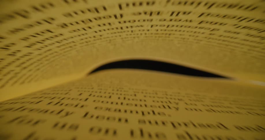Camera moving through the tunnel formed between the pages of a book over a table