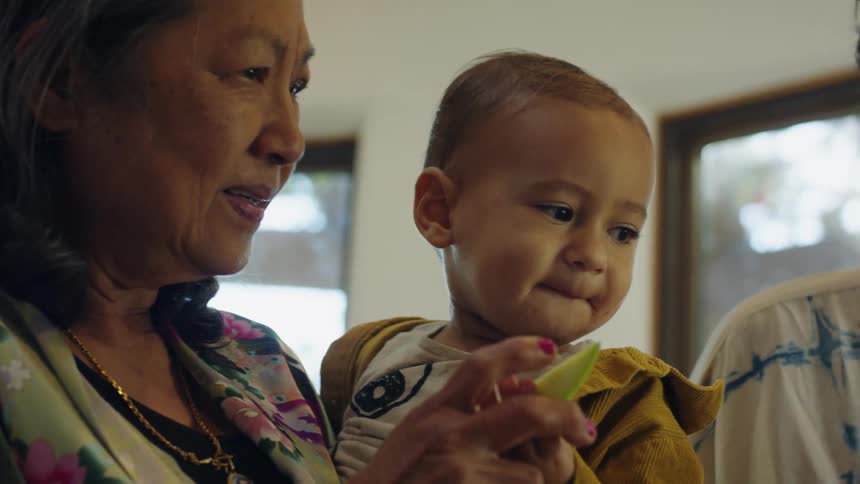A family of three is eating fruit indoors