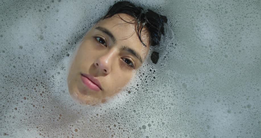 A woman is taking a bath in a bathtub