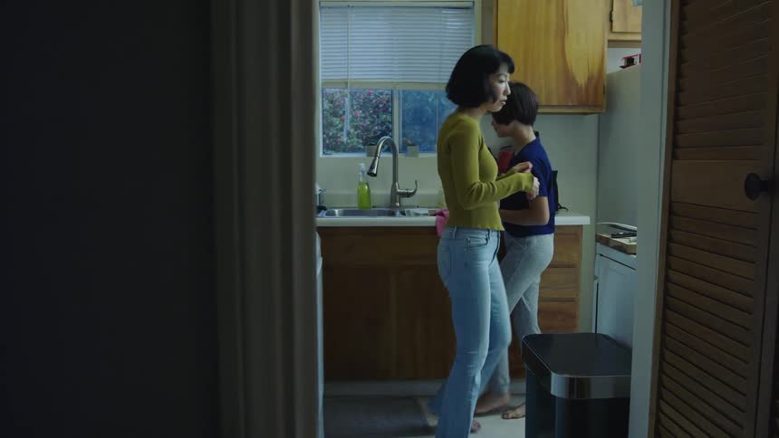 A mother and daughter preparing food in a home kitchen