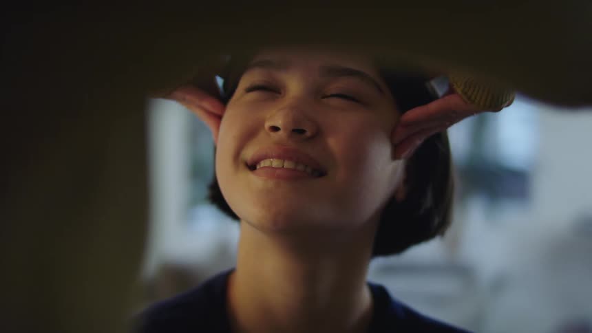 Woman gives a face massage to a happy smiling young girl at home