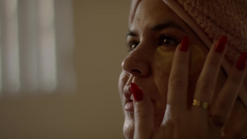 A woman is applying facial cream to their face