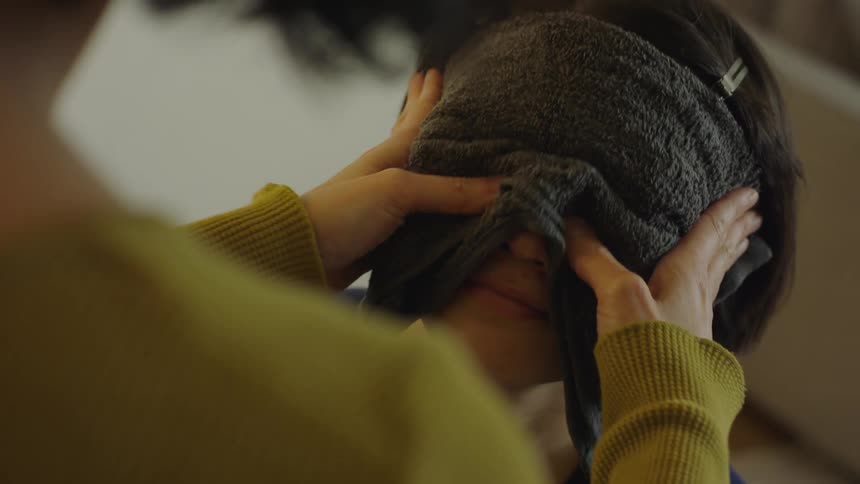 Woman massages another womans face through towel