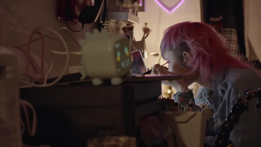 A girl is applying eyeliner at home