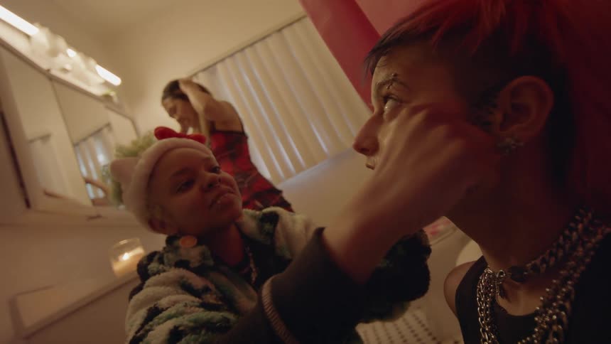 A woman gives another woman a face massage while another lady stands at the counter