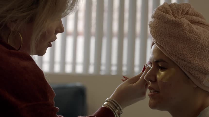 A woman is putting makeup on someone