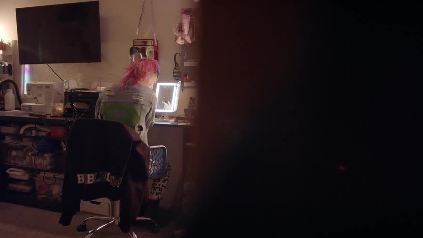 A woman is applying makeup in the mirror