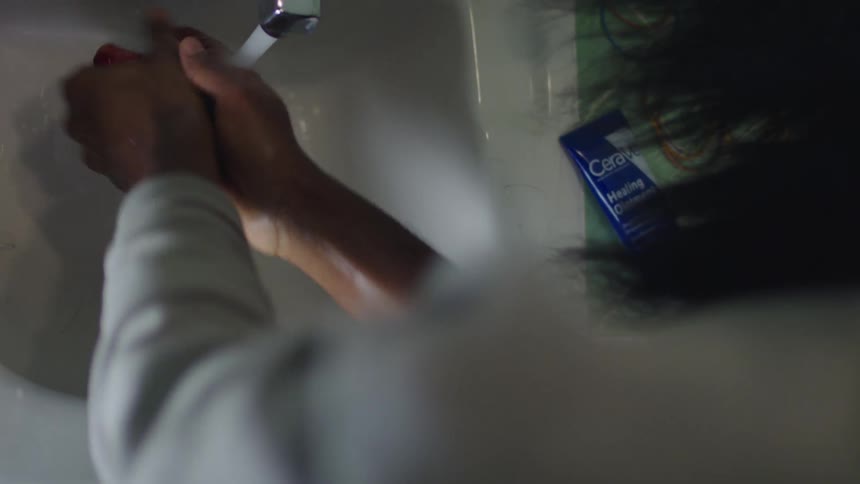 A female is washing her hands in a sink
