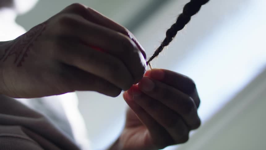 A person is having their hair braided