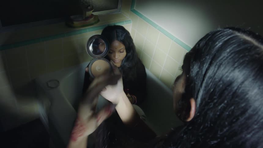 Two women are in a bathroom and applying makeup