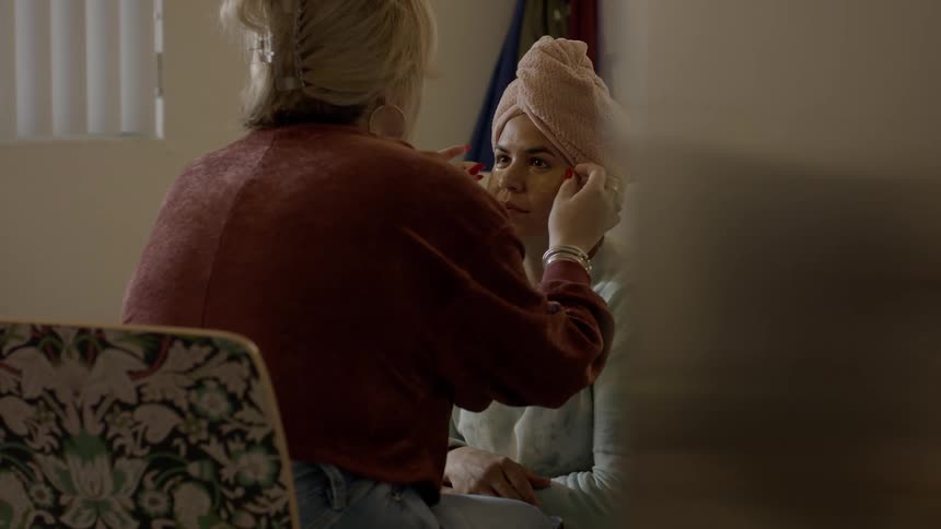 A woman is applying makeup to another person