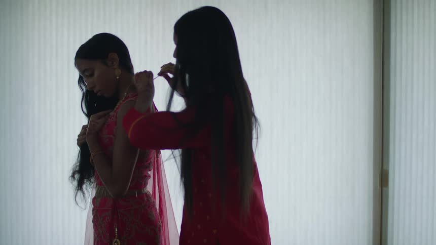 Two women are in a room fixing a dress
