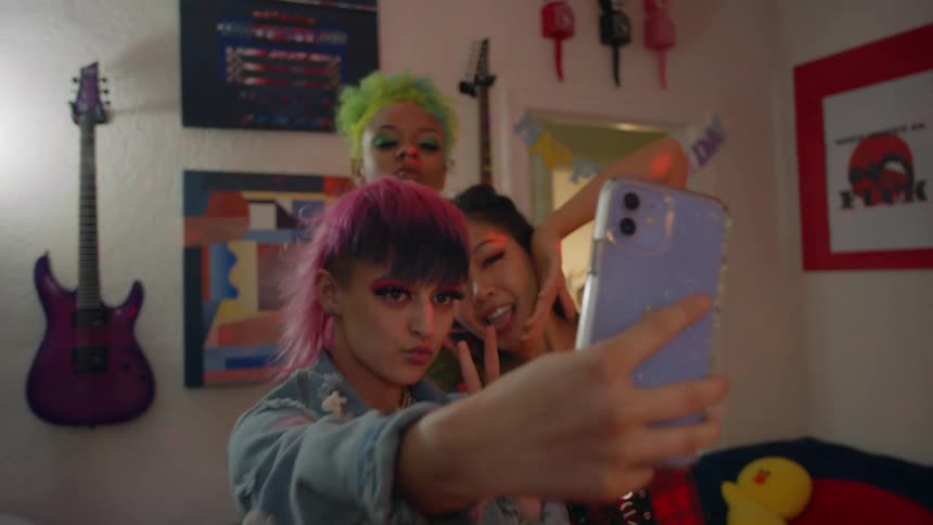 Three women are talking selfies indoors together