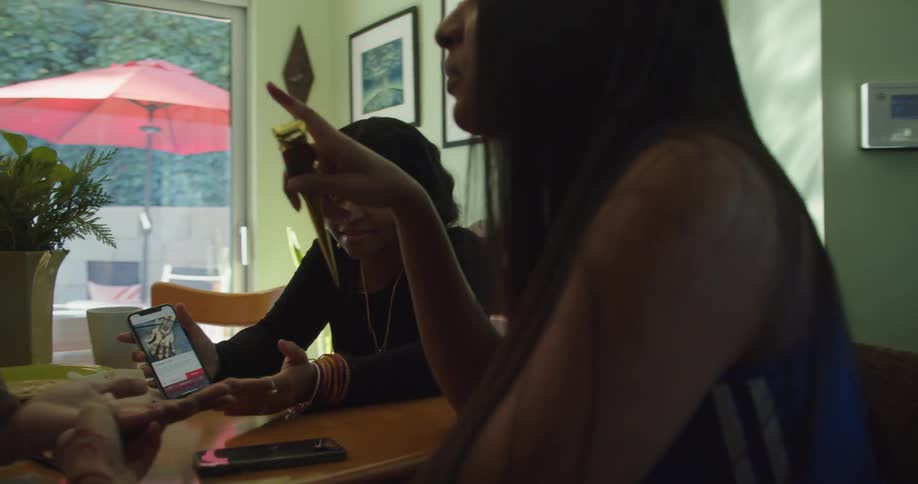 Group of young girls sitting at the dinning table at home talking
