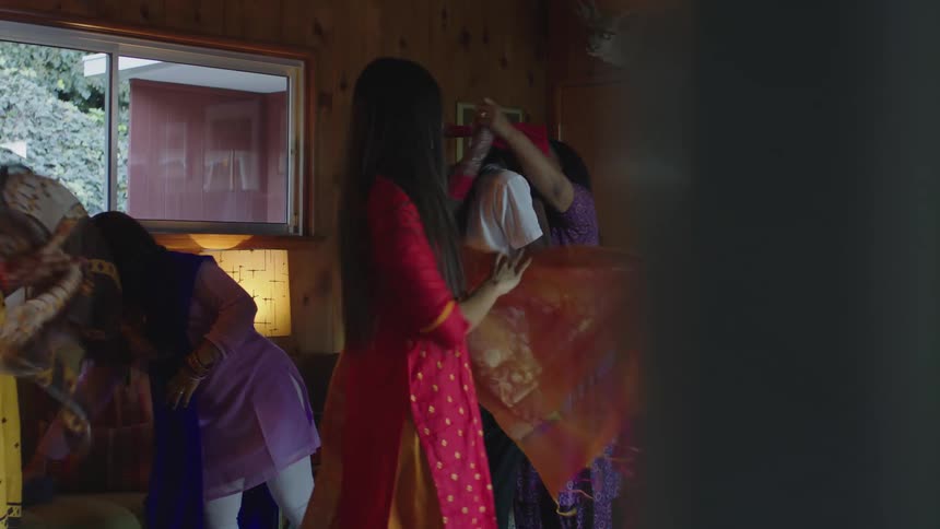 A group of women are helping each other put on their saris