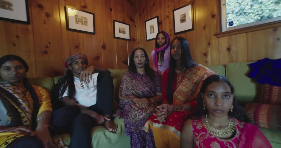 Indian family sitting on a couch in the living room at home