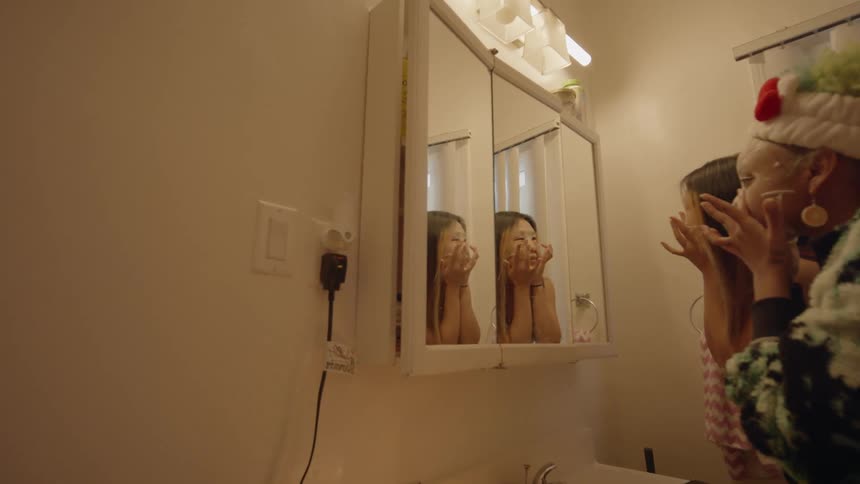 Two girls are putting cream on their face