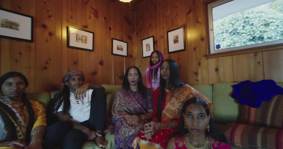 A group of people are sitting in the living room together