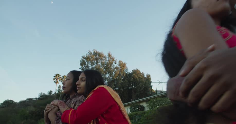 Four people are hugging outdoors in spring