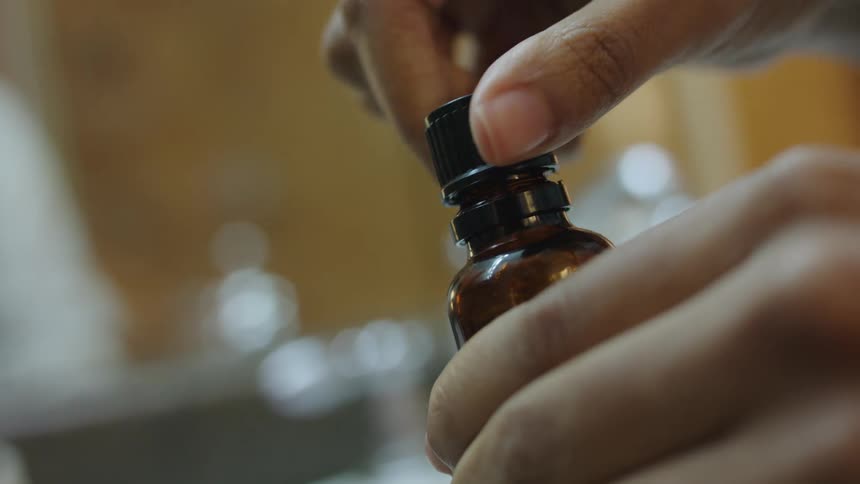 A woman opens a bottle of serum