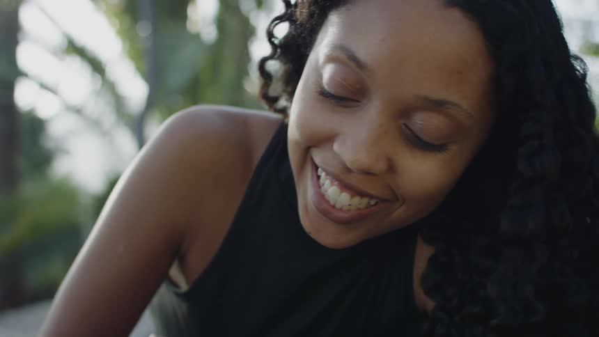 A woman is sitting outdoors and talking