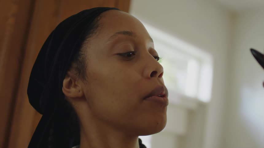 Woman applies makeup on another woman