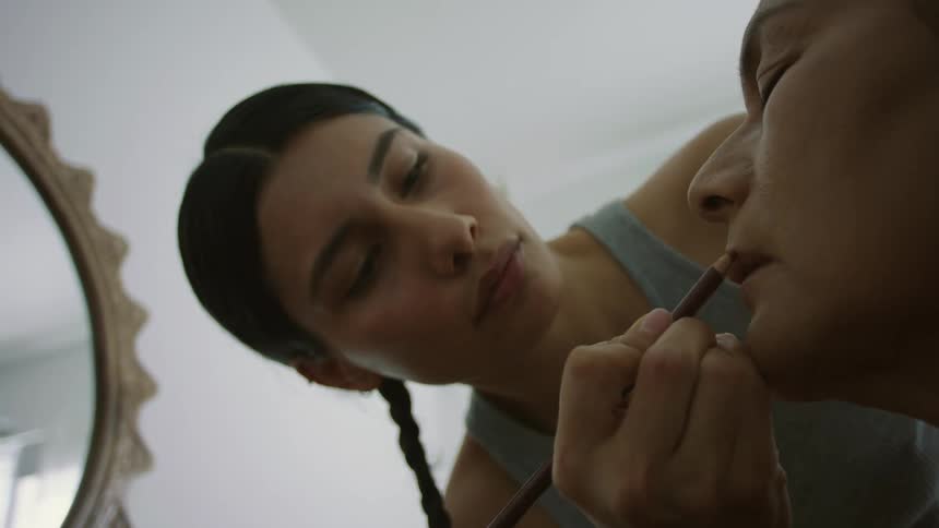 A woman is applying makeup on someone