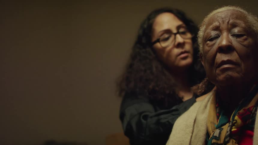 A young woman styles an elderly womans hair