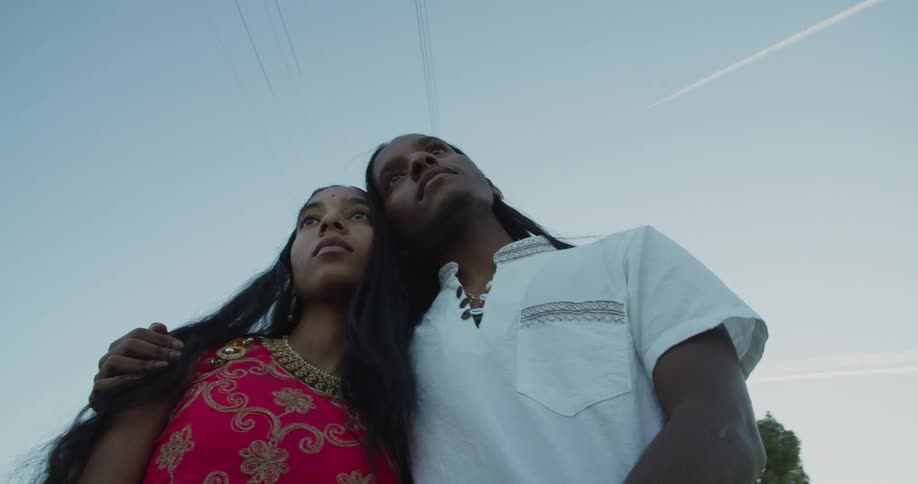 A man and woman stand together outside