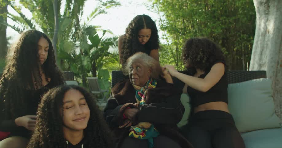 Teenagers brush an elderly womans hair