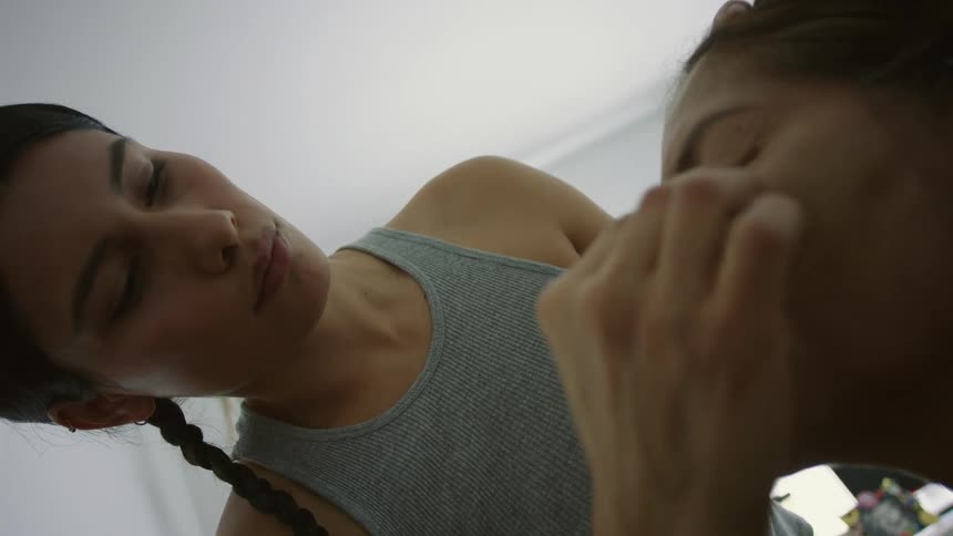 A woman is applying makeup with a pad