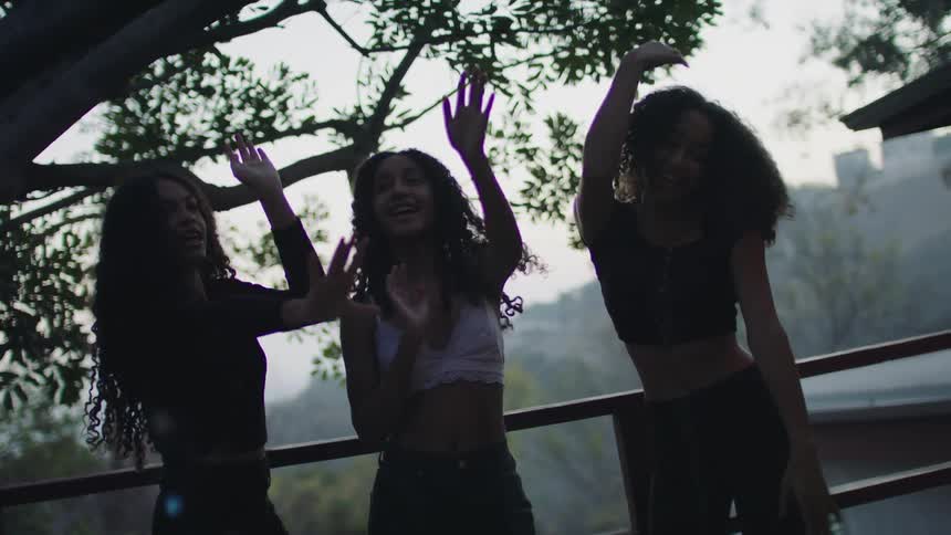 Three girls are dancing on the terrace